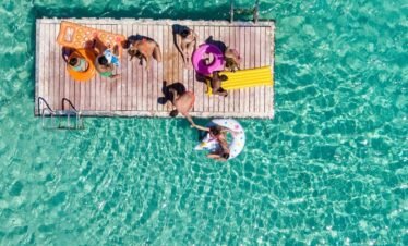 Tourists relaxing on a best travel agent in egyptfloating dock in crystal clear turquoise sea during a luxury island excursion by White Sky Travel